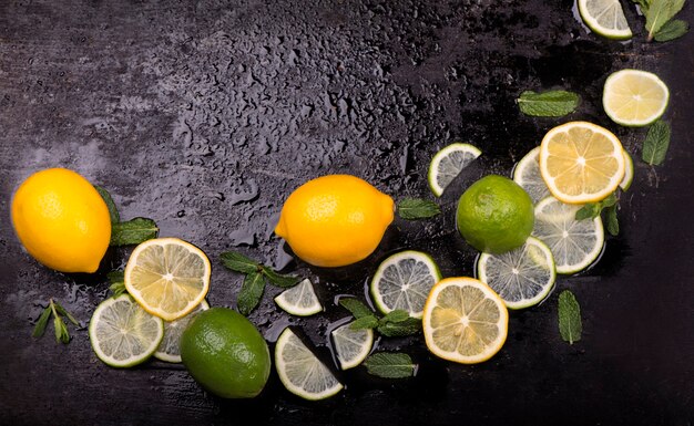 Fresh mint, lime and ice on a black table. Top view