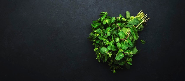 Foto menta fresca o menta piperita su sfondo scuro vista dall'alto del primo piano della pianta medicinale