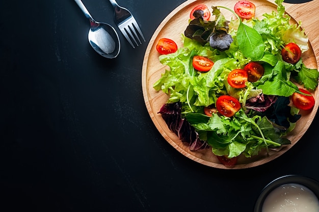 Fresh mixed vegetables salad on a wooden plate