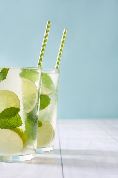 fresh mojito cocktail in glass on white wooden table