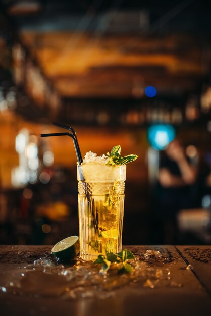 Fresh mojito in a glass and ice on bar counter