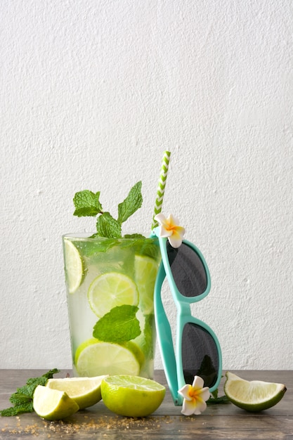 Fresh mojito and summer glasses on a rustic wood table