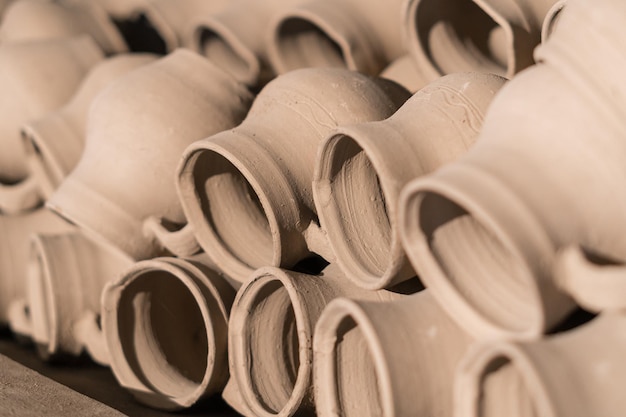 Fresh molded clay jars drying on a shelf in a potter's manufacturing studioLocal traditional craft and art concept