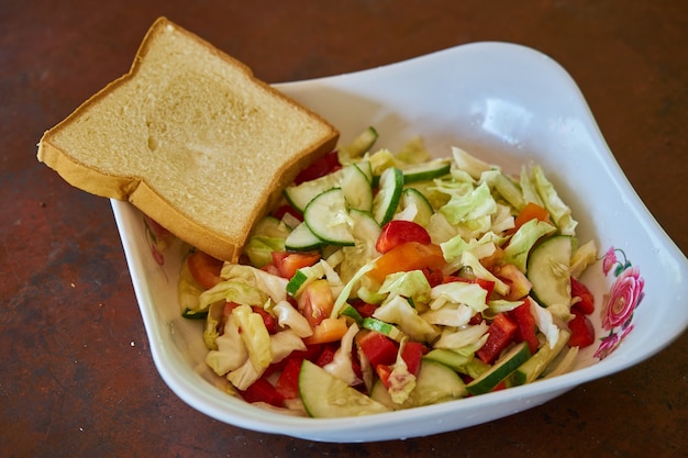 Fresh morning vegetable salad with bread on a table