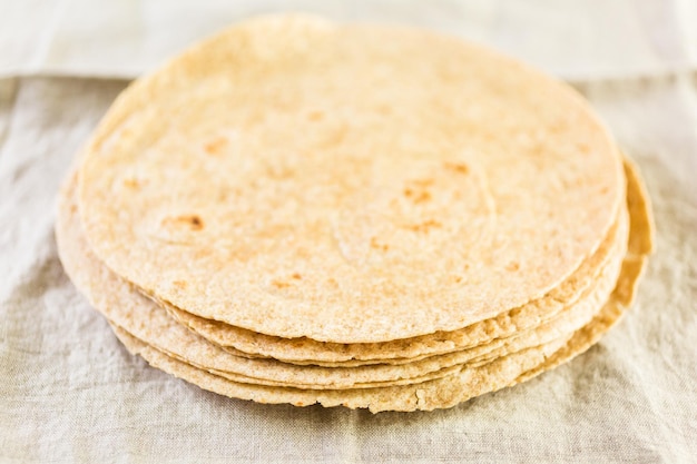 Fresh multi-grain tortillas on a linen dinner napkin.