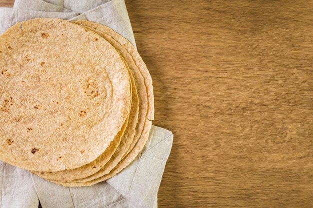 Fresh multi-grain tortillas on a wood background.