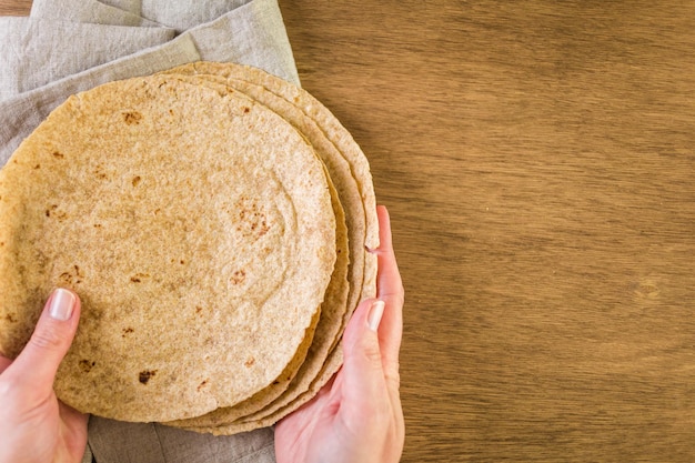 Tortilla multicereali fresche su uno sfondo di legno.