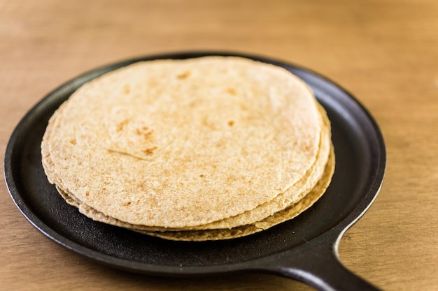 Fresh multi-grain tortillas on a wood background.