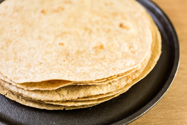 Fresh multi-grain tortillas on a wood background.