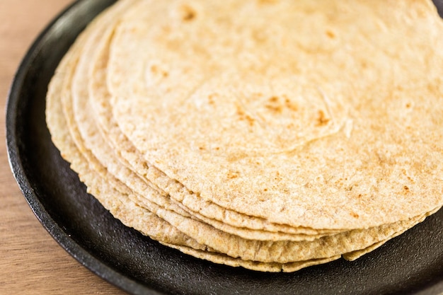 Fresh multi-grain tortillas on a wood background.