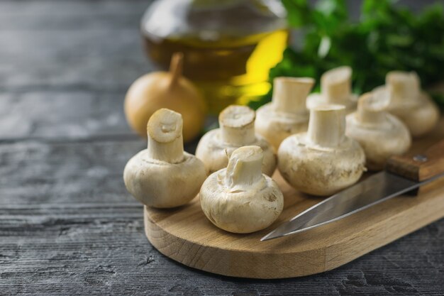 Fresh mushrooms on a cutting Board with a knife on a rustic wooden table Vegetarian food is on the table