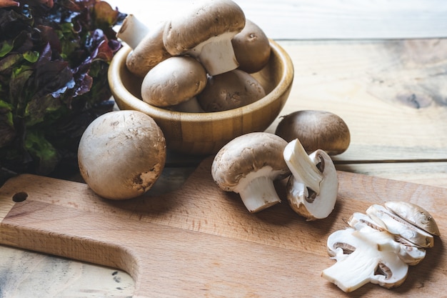 Fresh mushrooms in a wooden bowl on the table