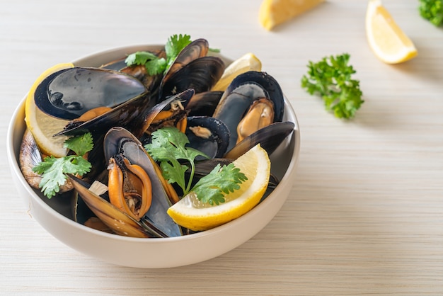 fresh mussels with herbs in a bowl with lemon
