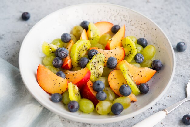 Fresh natural fruit salad bowl with Chia seeds, selective focus