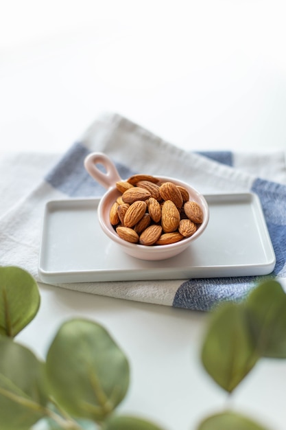 Fresh nut almonds in a ceramic bowl with towel