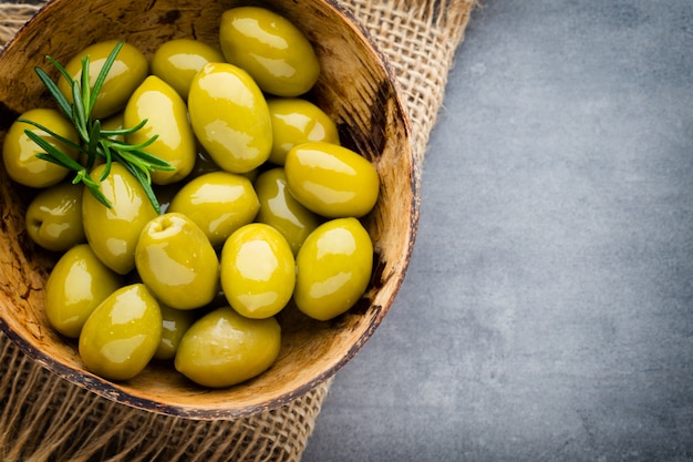 Fresh olives and gray background. Olives in bowl and spoon.