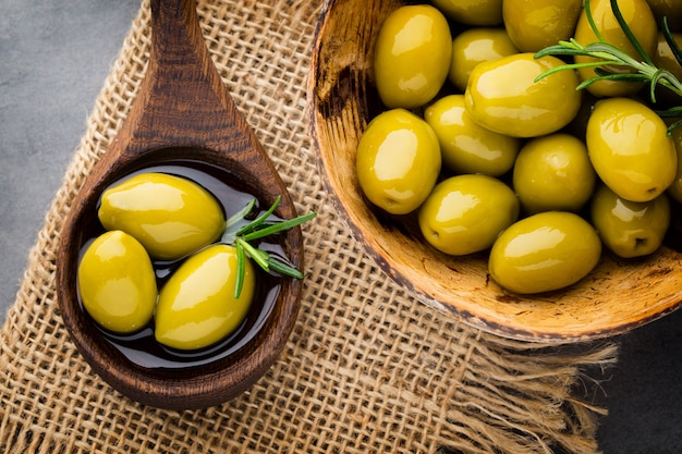 Fresh olives on wooden spoon and bowl