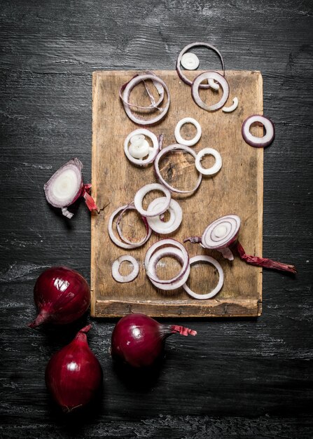 Fresh onion sliced on wooden Board on black rustic.