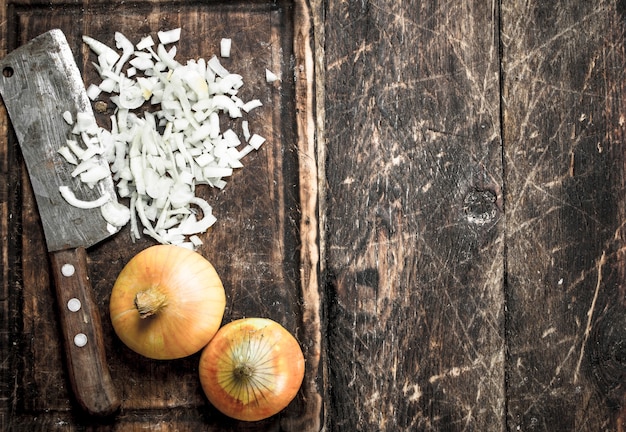 Fresh onion with old hatchet on a cutting board.