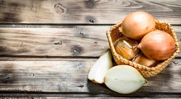 Fresh onions in a basket and slices of onion