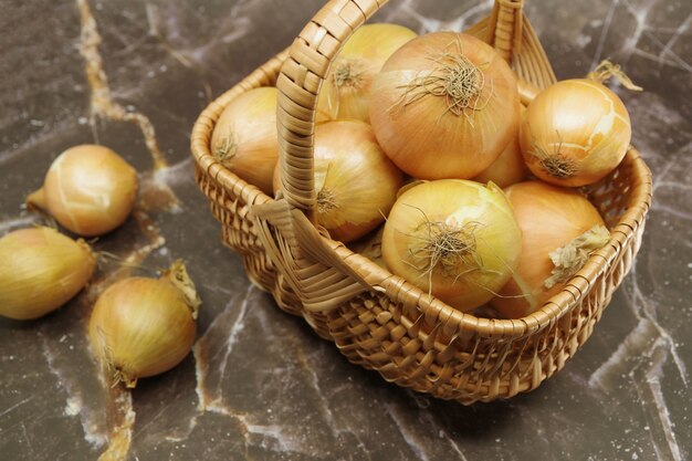 Fresh onions in a wicker basket. Basket with fresh onions. Closeup