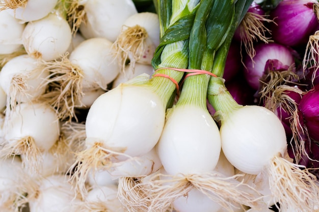 Fresh onons in a large pile at the local farmer's  market.