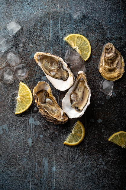 Fresh open oysters top view with lemon wedges and ice