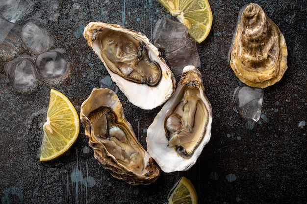 Fresh open oysters top view with lemon wedges and ice