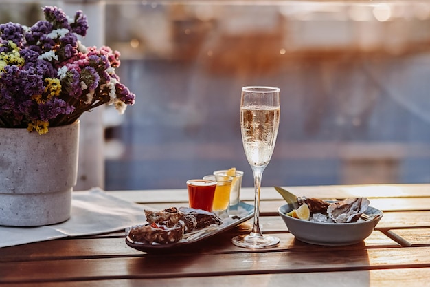 Fresh open oysters with a glass of chilled prosecco wine and set of shoot alcoholic cocktails served on table Seafood delicios