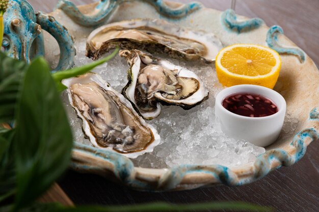 Fresh open oysters with sauce, lemon and a glass of wine