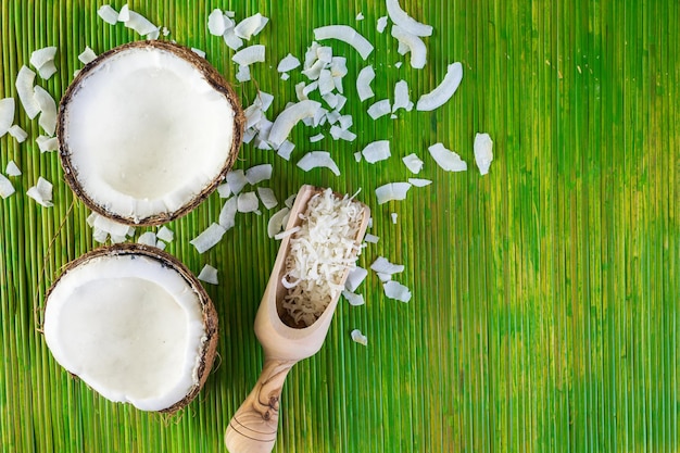 Fresh opened coconut on a green background.