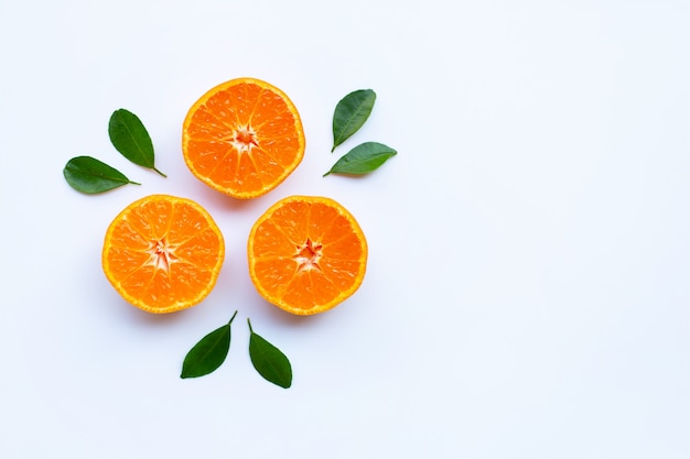 Fresh orange citrus fruit with green leaves on white.