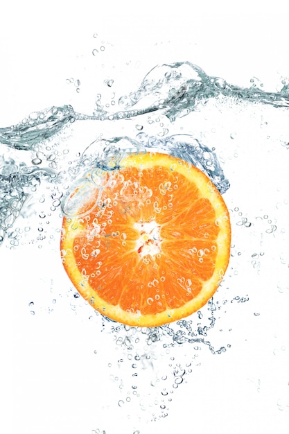 Fresh orange falling in water