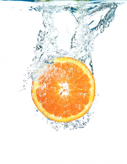 Fresh orange falling in water