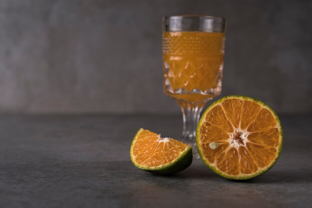 Fresh orange fruits and juice on stone table. 