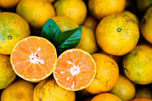 Fresh orange fruits with leaves as background