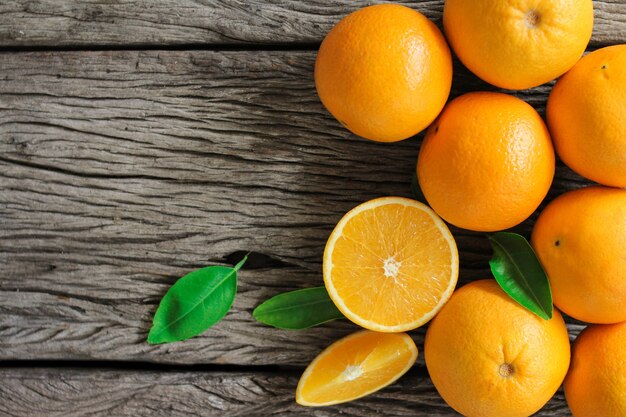 Foto frutta arancione fresca con foglie sulla tavola di legno