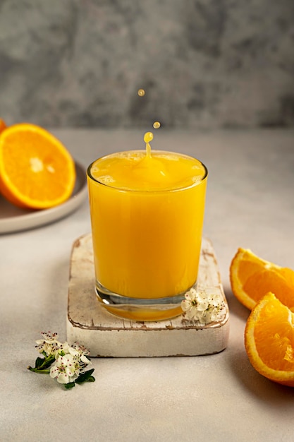 Fresh orange juice in glass and orange fruit Splashing orange juice drops splashes