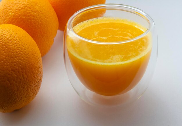 Fresh orange juice in glass and oranges on white background healthy eating copy space