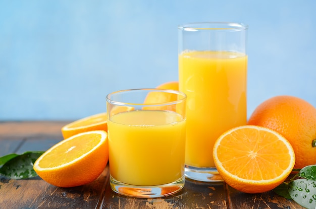 Fresh orange juice in a glasses on old wooden table.