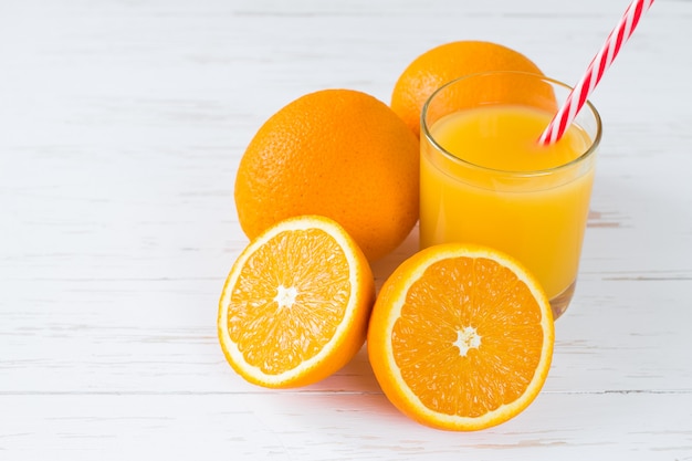 Fresh orange juice on white wooden background with copy space