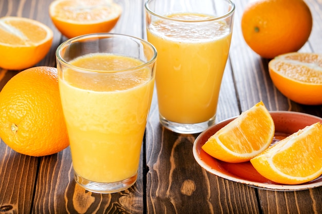 Fresh orange juice with fruits on glasses