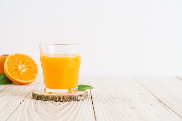 Fresh orange juice on wood background