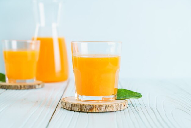 Fresh orange juice on wood background