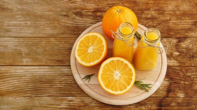 Fresh orange juice on wooden table on a wooden board