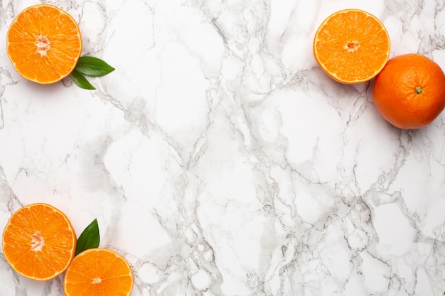 Fresh orange mandarin on marble surface with copyspace , fruit flatlay, summer minimal and kinfolk composition