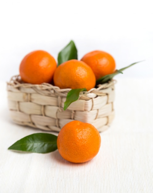 Fresh orange mandarins with leafs in basket