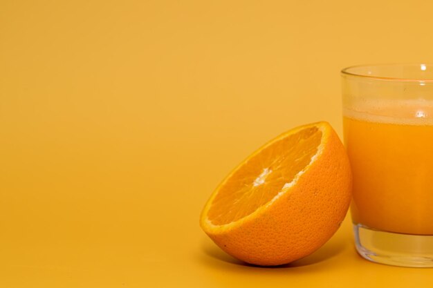 Fresh orange and orange juice on yellow background