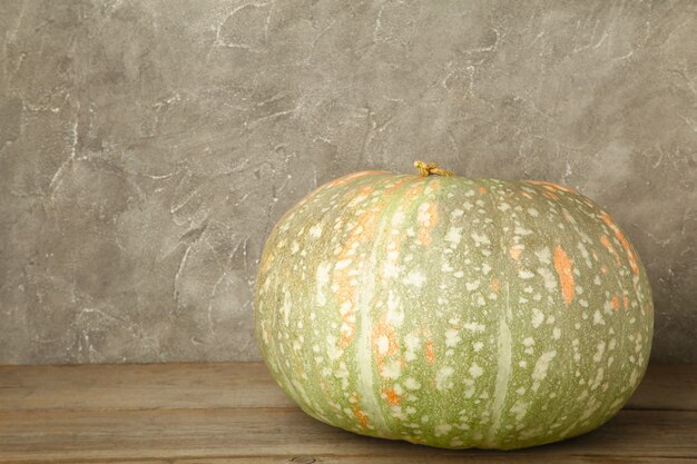 Fresh orange pumpkin on grey concrete background. Top view