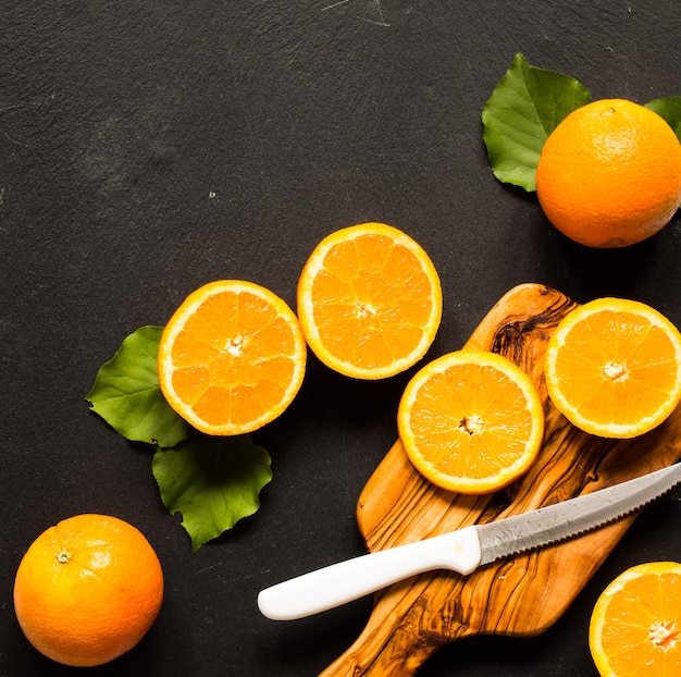 Photo fresh orange with leaves on wooden background